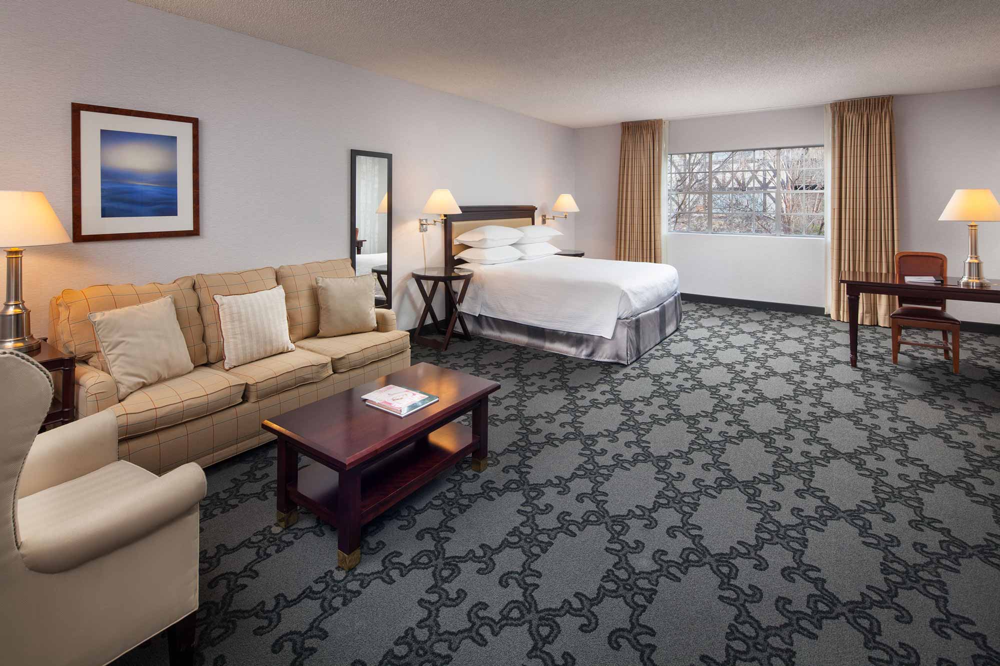 Large royal junior suite with king bed, sofa seating, and extra space for guests seeking upgraded Anaheim hotel rooms
