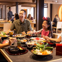Family with dad, mom, teen, and young girl enjoy Japanese-inspired cuisine at Hanagai Japanese Restaurant in Anaheim, California.